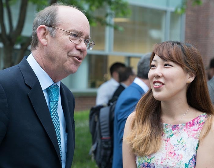 David Eisenhower talking to a student while both are outdoors.