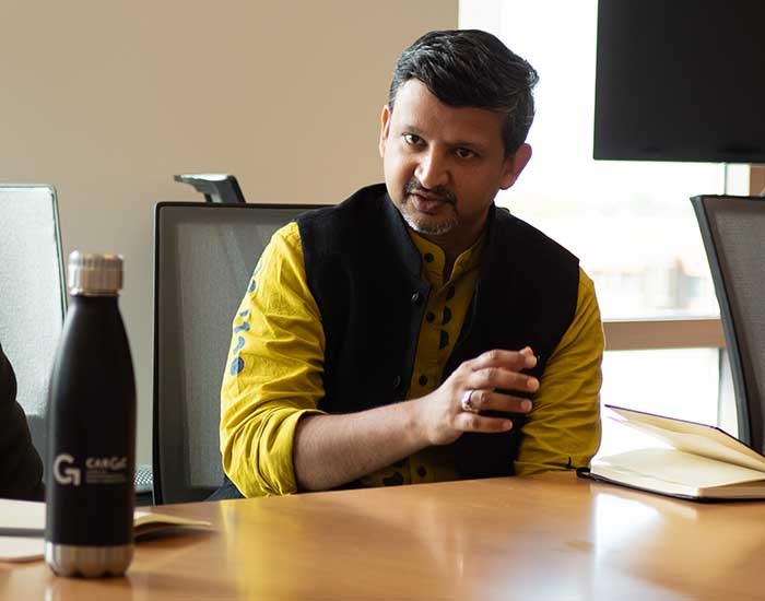 Aswin Punathambekar seated at a table, talking